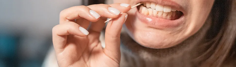 woman picking teeth with toothpick