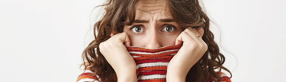 woman covering her mouth in fear