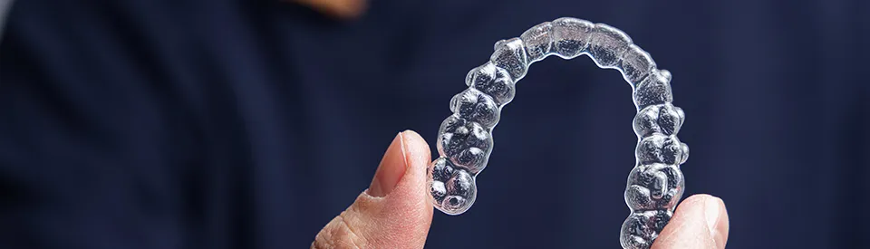 dentist holding clear aligner