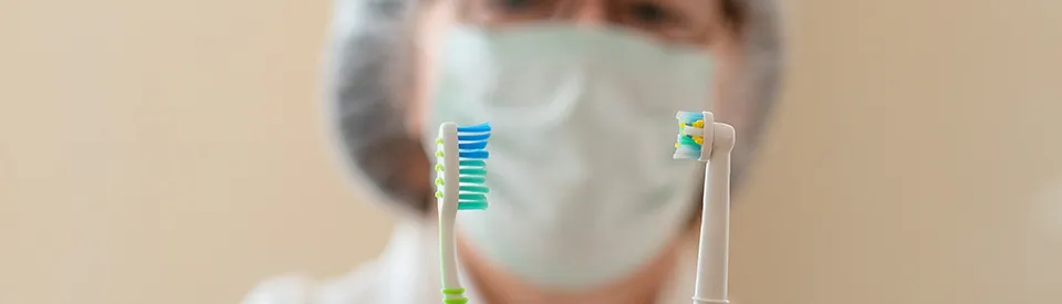 two tooth brushes being held 