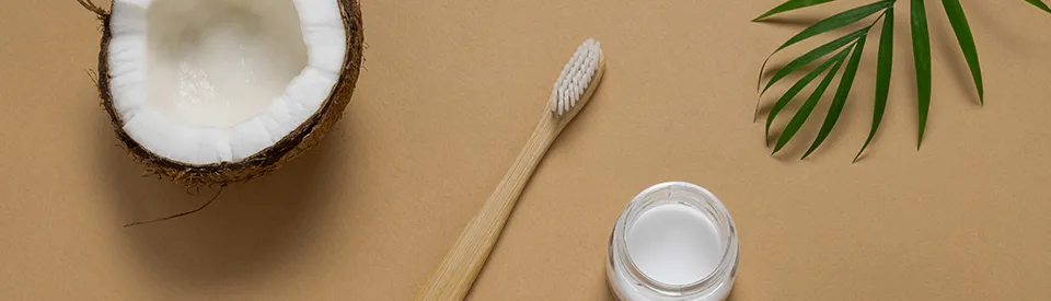 toothbrush and a coconut on yellow background