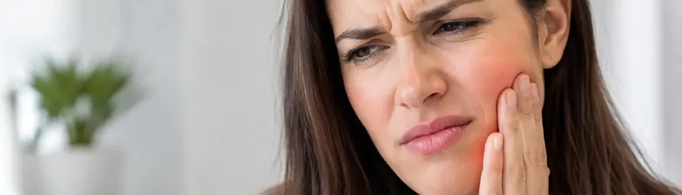woman holding jaw in pain