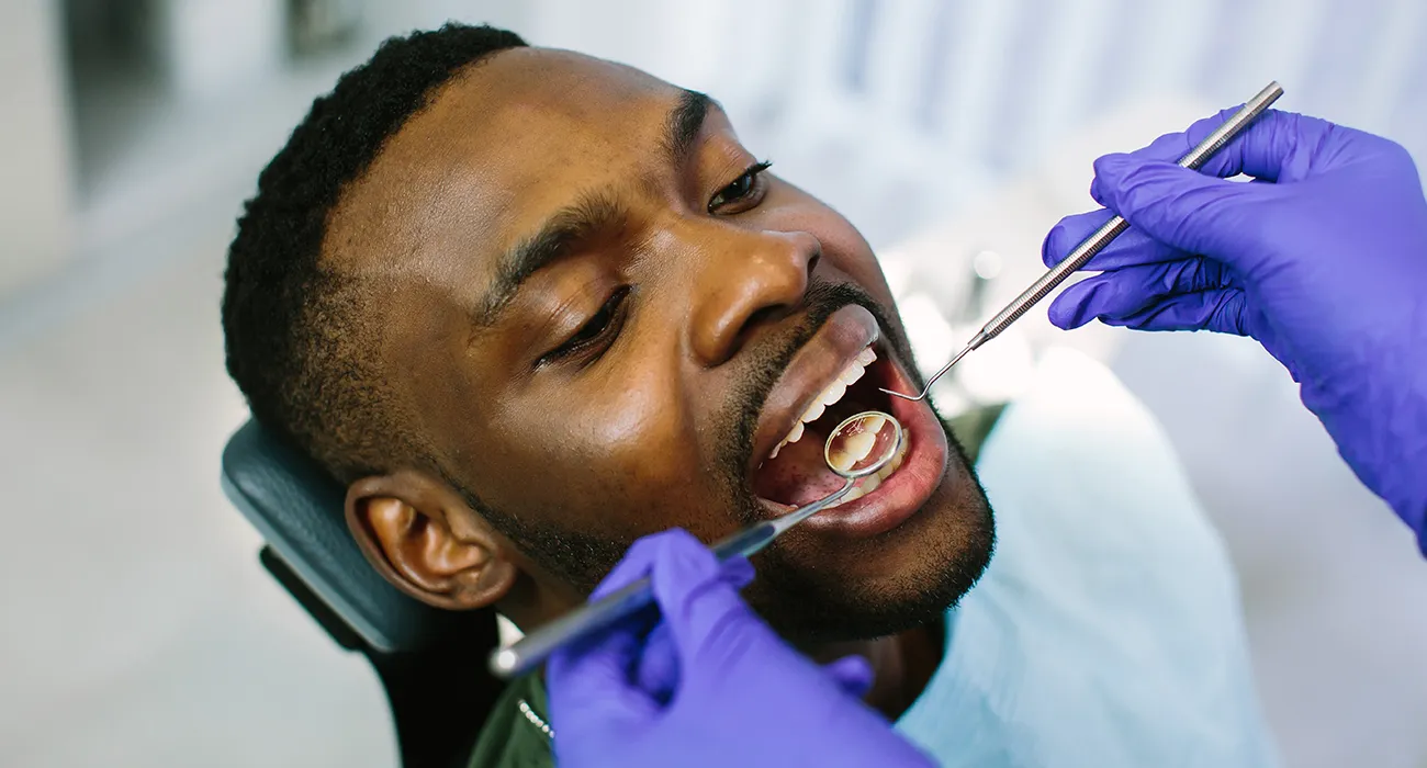 black man being inspected by dentist