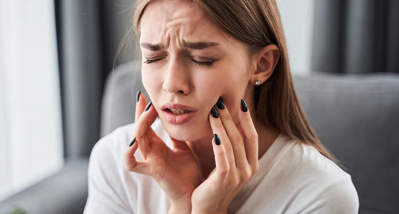girl holding jaw in pain