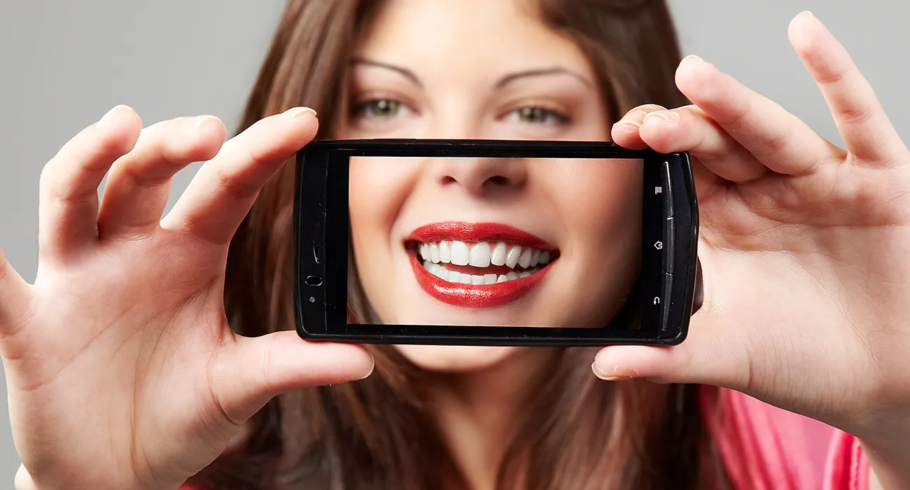 woman holding camera phone up to face