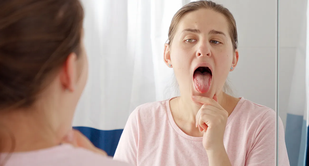 girl inspecting her mouth