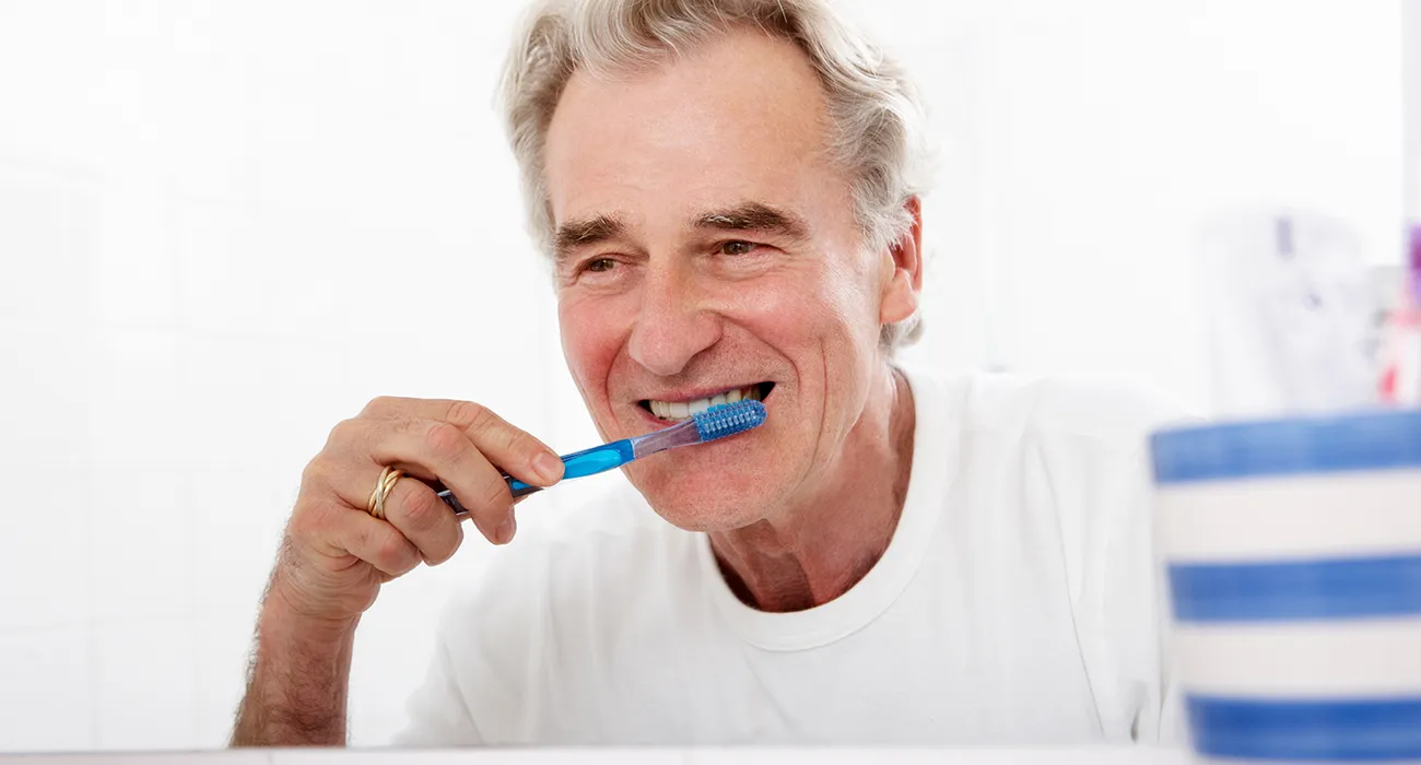 man brushing teeth in bathroom