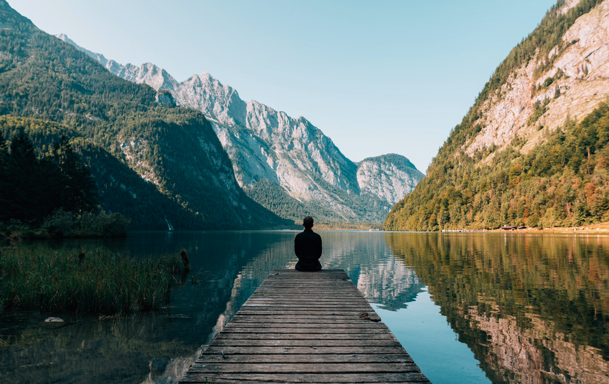 A Person Sitting on Wooden Planks Across the Lake Scenery. Photo by S Migaj from Pexels