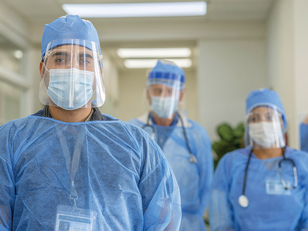 three masked hospital staff.