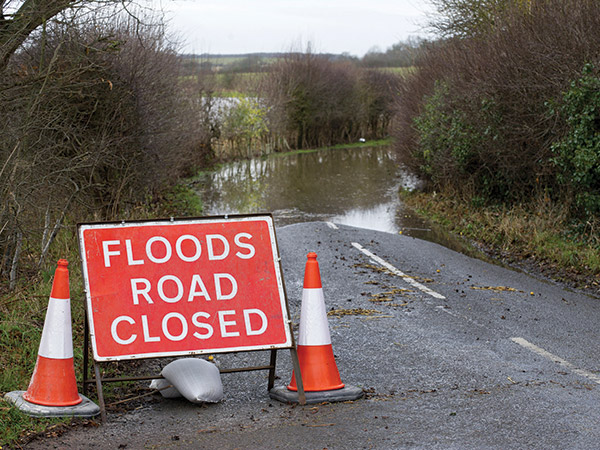 floods road closed sign, flooding in background