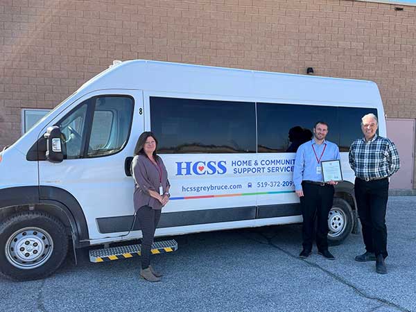 HCSS team leader and executive director pose with Rick Byers and HCSS van