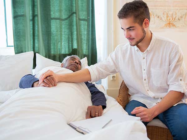 Man holding elderly patient's hand