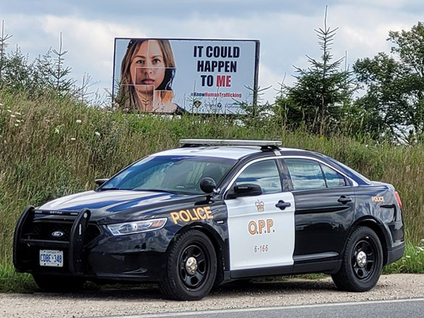 OPP car parked in front of Human Trafficking billboard