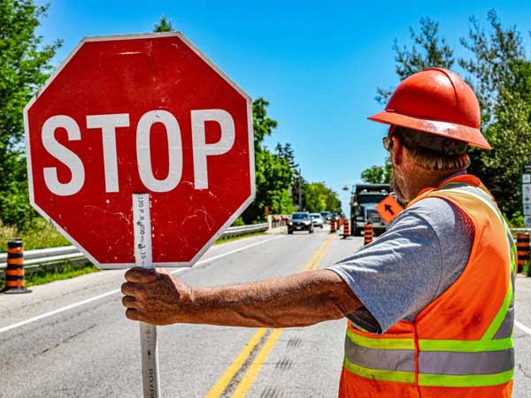 Man holding stop sign at a road construction site