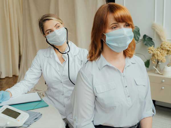 Doctor and patient wearing masks in hospital