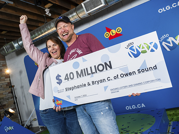 Winners of $40 Million Lotto Max holding large cheque.