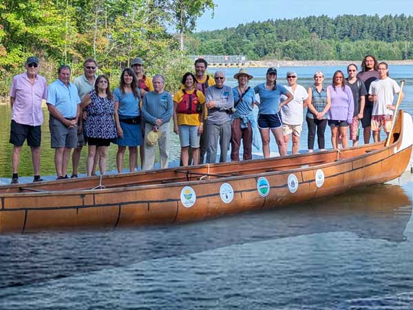 The group of paddlers standing on dock behind the Big Canoe