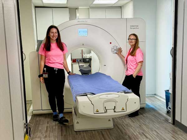 Staff pose with the Computed Tomography (CT) scanner at Brightshores Owen Sound Hospital