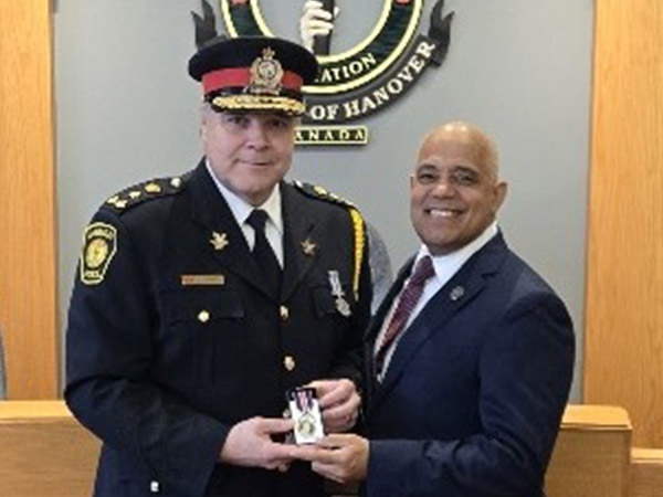 Police Chief Knoll is awarded metal by Selwyn Hicks, chair of Hanover Police Services Board.