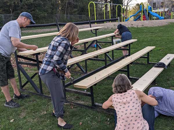 Eugenia volunteers work to repair bleachers