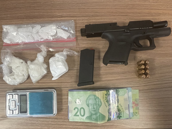 Gun, bullets, drugs, weigh scale and money on a table.
