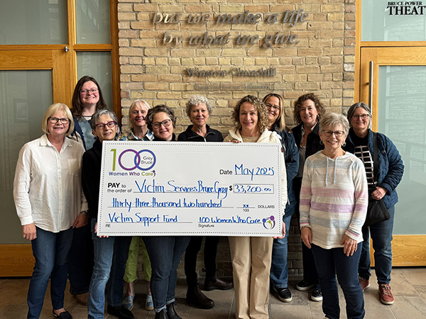 group of women behind a big cheque