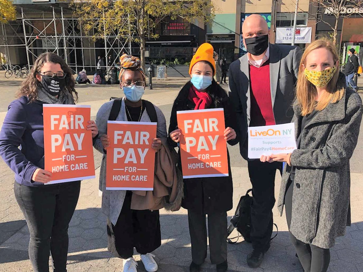People holding signs that read 'Fair Pay for Home Care'